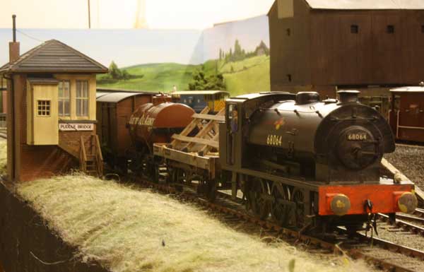 A J94 passes the signal box with a freight train.
